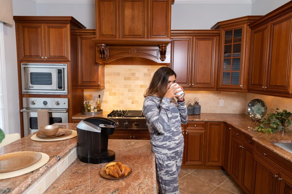 resident drinking coffee inside kitchen in residential unit
